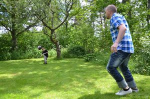 Son & far spelar boll gräsmatta