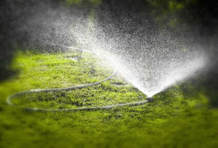 Irrigation of lawns Watering the lawn of a private house with the help of irrigation sprinkler.